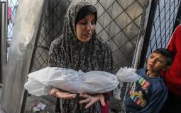 أم تودع طفلتها الشهيدة في غزة -أرشيف-