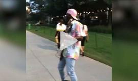 موسيقي أمريكي يعزف الغيتار خلال قيادته للوح التزلج