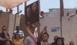 مناظر الشبيبة الفتحاوية يرفع صورة "عباس وبيريز" خلال المناظرة الانتخابية أمام الكتلة الإسلامية في جامعة بيرزيت