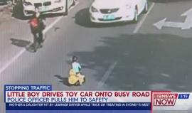 طفل صيني يقود دراجته البلاستيكية على طريق مزدحم بالسيارات