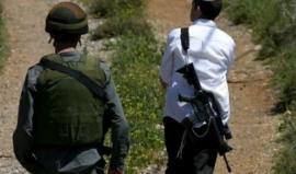 مستوطن مسلح برفقة أحد جنود الاحتلال