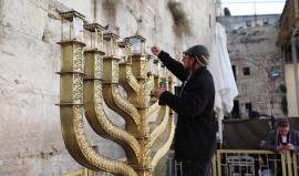 مستوطن يجهز الشمعدان في عيد الحانوكاه