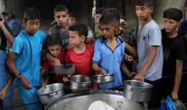 فلسطينيون يتجمعون لتلقي وجبات طعام من مطبخ خيري في مخيم النصيرات وسط قطاع غزة