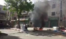 شاهد شبان يشعلون اطارات في منطقة باب الزاوية في الخليل قرب حاجز