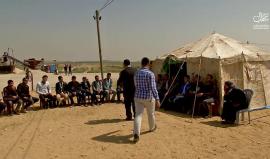 محاضر جامعي يقيم محاضرة لطلابه في مخيم العودة على حدود غزة الشرقية