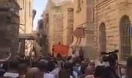 هتافات ضد بطريرك الروم الأرثدوكش رفضاً لبيعه أملاكاً للمستوطنين، خلال مسيرة باب الخليل بالقدس المحتلة.