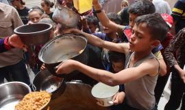 طفل فلسطيني ينتظر دوره للحصول على طعام من تكية خيرية بغزة