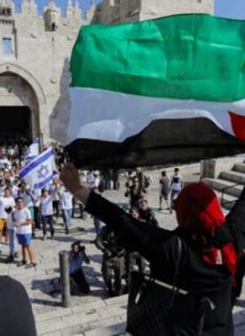 فلسطينية ترفع علم فلسطين في وجه مسيرة الأعلام الاستيطانية بالقدس - أرشيف