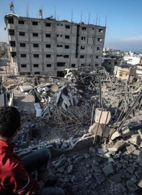 طفل غزي يجلس إنقاذ منزله المدمر