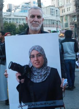 القيادي جمال الطويل يحمل صورة كريمته الصحفية الأسيرة بشرى  _أرشيفية_