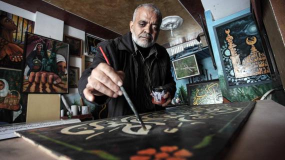 فنان فلسطيني يعيل أسرته بالعمل كرسام وخطاط منذ أكثر من 38 عامًا