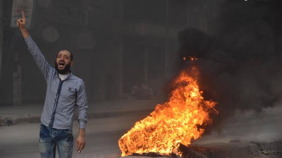 السوريون في حلب يشعلون الإطارات للتغطية على الطيران السوري والروسي