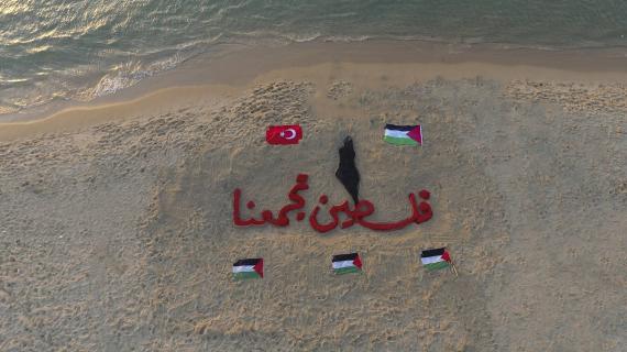 رسم على بحر شاطئ غزة بعنوان :"فلسطين تجمعنا"