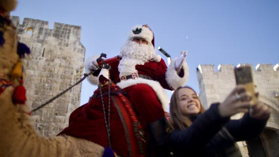 بابا نويل يوزع شجرة عيد الميلاد على المواطنين في البلدة القديمة بمدينة القدس