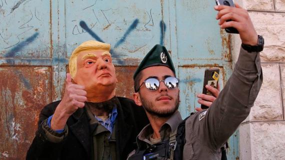 جنود الاحتلال يلتقطون صوراً مع مجسم لترامب