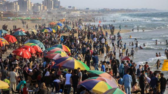 الغزيون يقضون أوقاتهم على شاطئ بحر غزة مع الأجواء الحارة وعطلة عيد الفطر