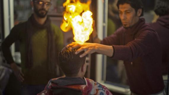 حلاق من قطاع غزة يقص شعر زبائنه بالنار