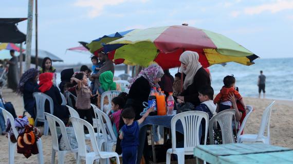 في ظل الأجواء الحارة وأزمة الكهرباء.. عائلات تفطر على شاطئ بحر غزة