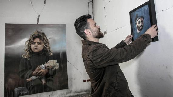 فنان فلسطيني يعرض لوحاته داخل أنقاض برج المجمع الايطالي