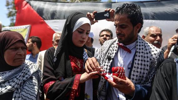 عروسان يعقدان قرانهما في خمية التضامن مع الاسرى المضربين المقامة بساحة السرايا وسط مدينة غزة