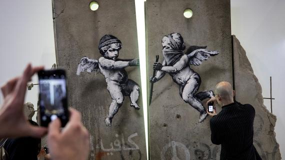 الفنان بانكسي يبهر العالم بلوحة فنية عن جدار الفصل في معرض لندن السياحي