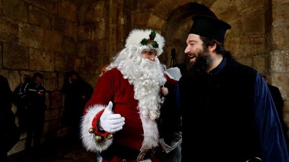 رجل بشخصية "بابا نويل" يتجول في القدس يوزع الهدايا مع حلول موسم الأعياد