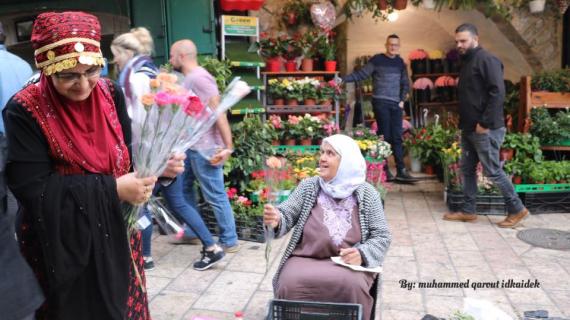 مقدسيات يوزعن الزهور والحلوى بمناسبة يوم المرآة العالمي
