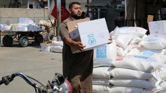 لاجئون فلسطينيون يحصلون على المساعدات الغذائية من وكالة الأونروا