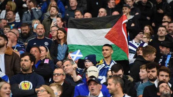 مشجعو كرة القدم يرفعون العلم الفلسطيني خلال مباراة بين منتخب اسكتلندا ومنتخب الاحتلال