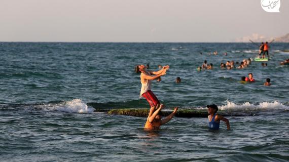 فلسطينيون يتسمتعون بوقتهم على شاطئ دير البلح وسط قطاع غزة