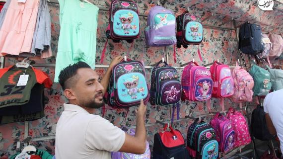 فلسطينيون يشترون الزي المدرسي للعام الدراسي الجديد في مدينة غزة
