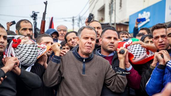والد الشقيقين الشهيدين ظافر وجواد الريماوي يحمل جثمانيهما خلال تشييعهما بعد ارتقائهما برصاص الاحتلال في كفر عين شمال غرب رام الله