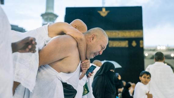 مشهد برّ ووفاء من رجل لوالده حيث يحمله على ظهره خلال الطواف حول الكعبة المشرفة