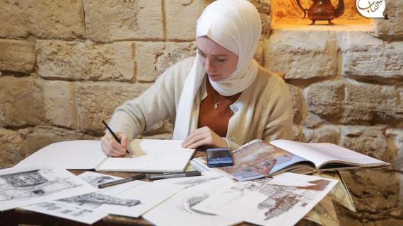 المهندسة المعمارية الفلسطينية ولاء شبلاق (27 سنة) ترسم المباني القديمة لتوثيق آثار البلدة القديمة في مدينة غزة