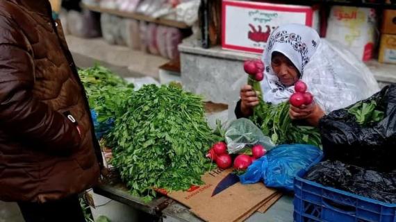 البائعة "ام خالد" من مخيم النصيرات وسط قطاع غزة تفترش الأرض في ظل الأجواء الماطرة