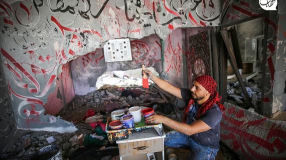 الفنان الفلسطيني أيمن الحصري يرسم جدرايات بالخط العربي على أحد المنازل التي دمرت بفعل قصف الاحتلال في بيت لاهيا شمال قطاع غزة
