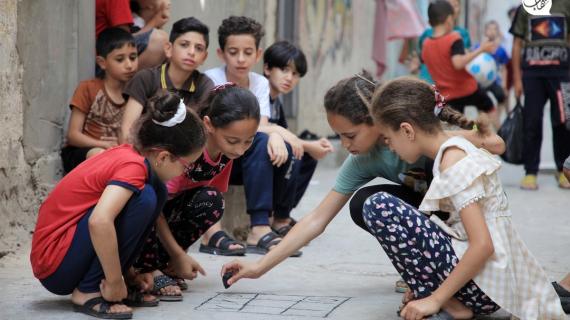 أطفال فلسطينيون يلعبون بين أزقة مخيم النصيرات للاجئين وسط قطاع غزة في اليوم العالمي للاجئين