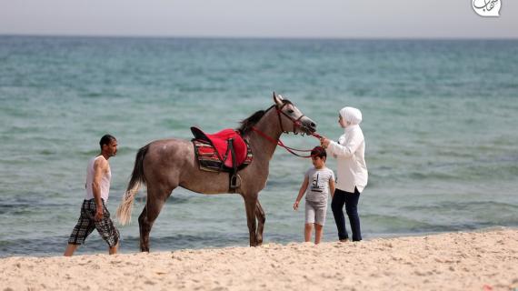 مواطنون يستمتعون بأوقاتهم على شاطئ بحر غزة مع بدء الإجازة الصيفية للمدارس