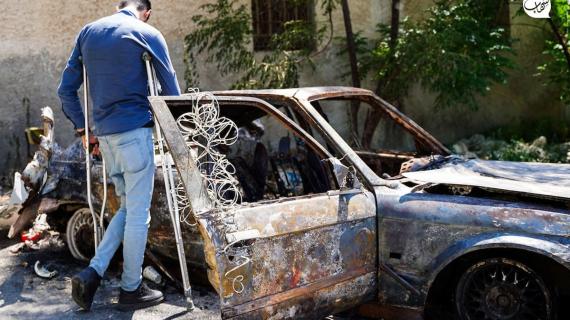 فلسطيني يتفقد سيارة بعد أن فجرتها قوات الاحتلال في قرية كفر دان بالقرب من جنين