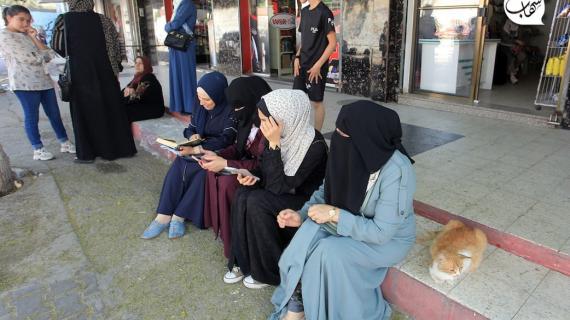 بين قراءة القرآن وقلب يلهج بالدعاء.. أهالي طلبة الثانوية العامة عند أبواب مدارس أبنائهم في أول اختبارات التوجيهي في قطاع غزة