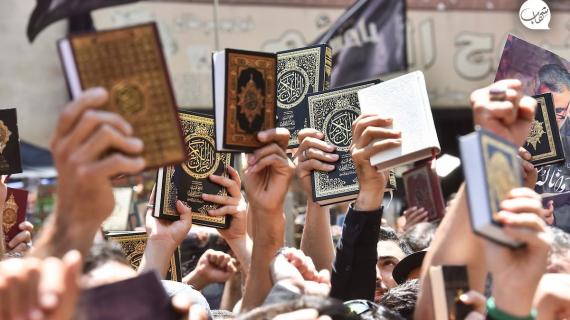 متظاهرون يرفعون مصاحفهم أثناء مشاركتهم في مظاهرة دعت إليها حركة حزب الله اللبناني