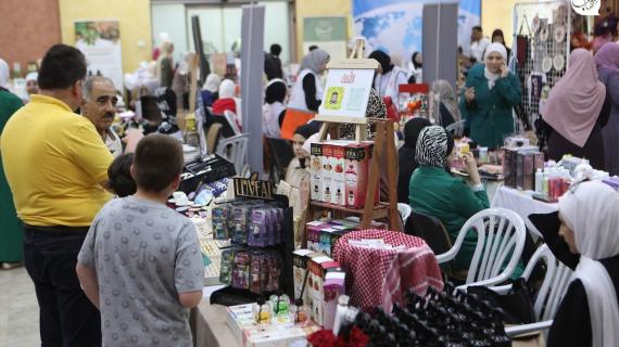 فلسطينيون يحضرون معرض للاشغال اليدوية "بازار جفرا" في مدينة الخليل