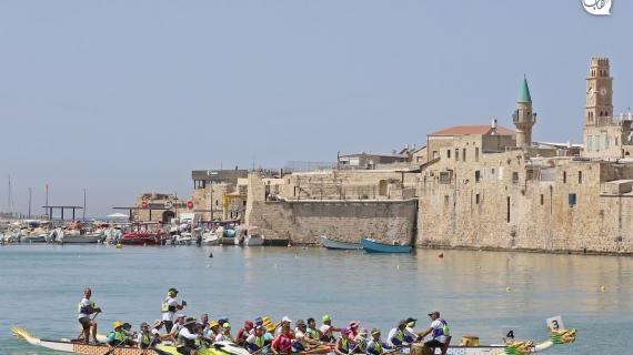 متسابقون يشاركون في سباق قوارب التنين في عكا