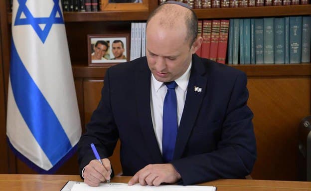 نفتالي بينت وخلفه صور للجنود غولدين وشاؤول